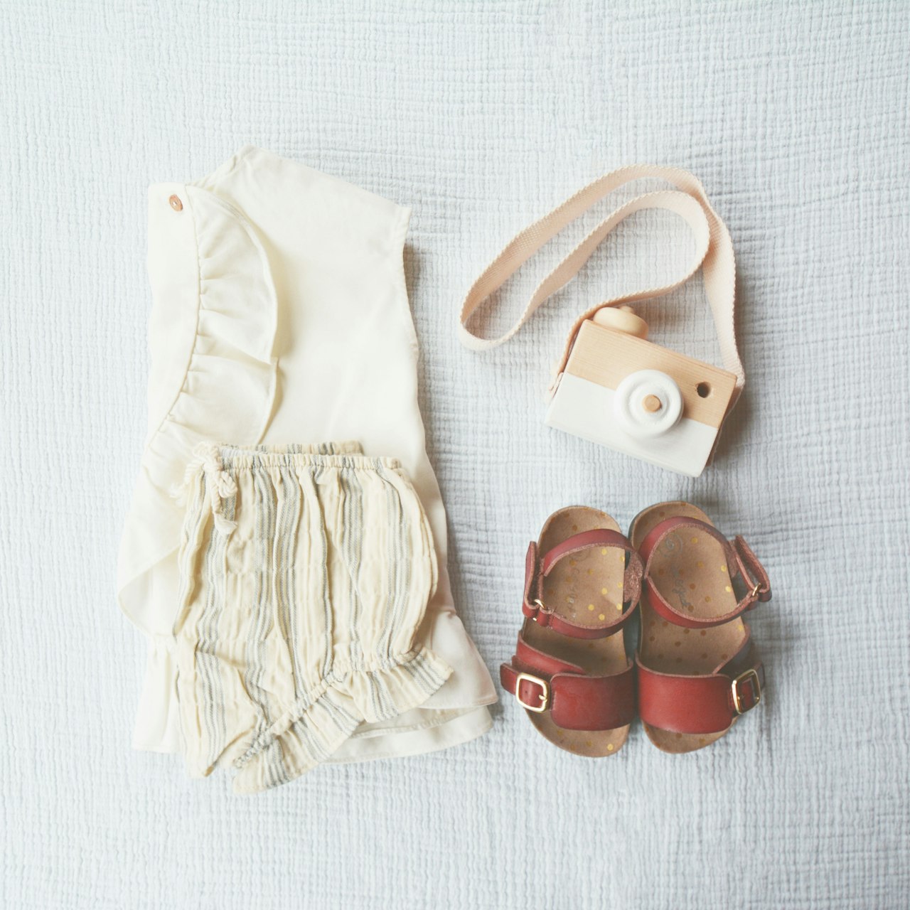 Babykleding en kleine accessoires op een zachte deken