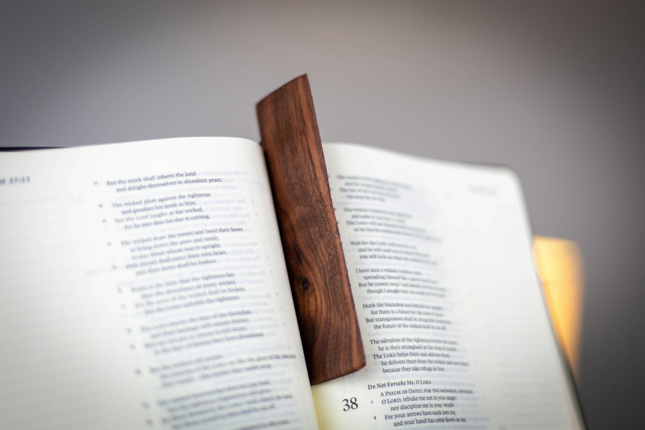 Een open boek met een houten boekenlegger