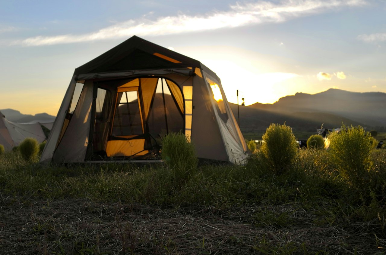Een tent op een open veld tijdens een kampeertrip