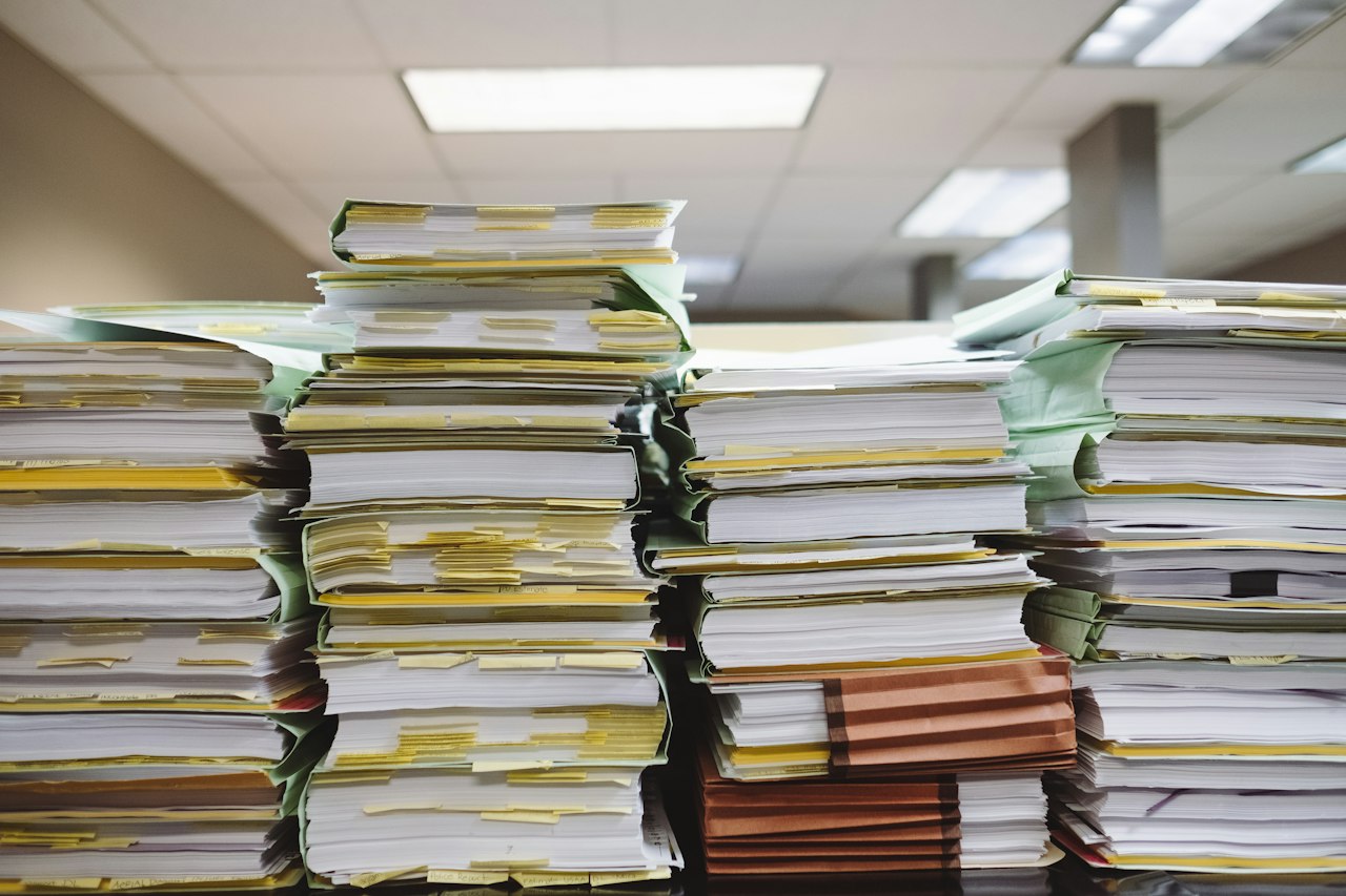 Papieren documenten en ordners op een bureau