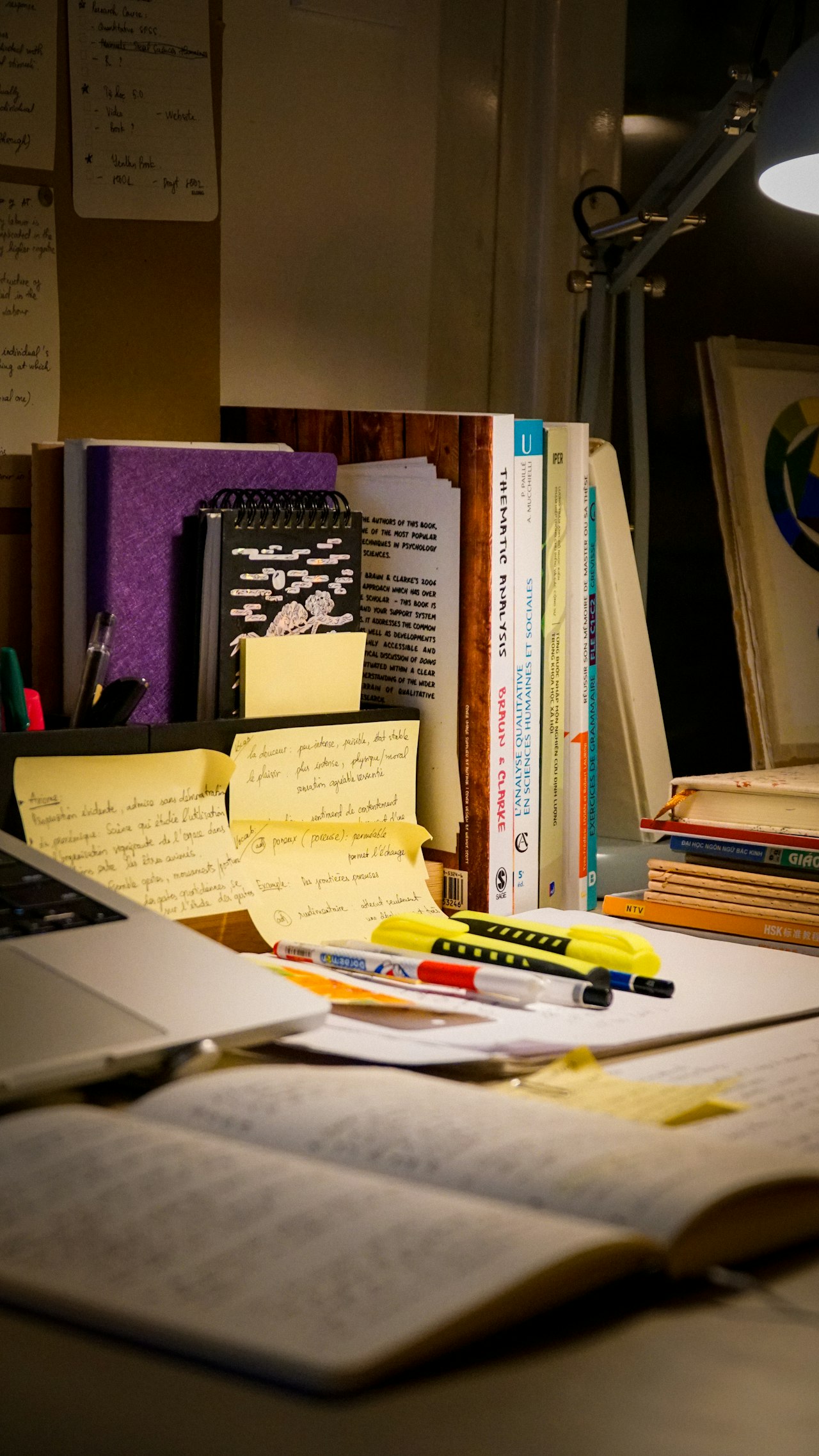 Een bureau met open boek, laptop en studiemateriaal